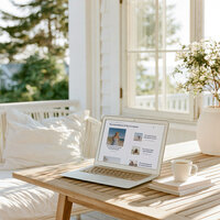 Laptop mockup of a one-page website template's resources section on a coastal porch table