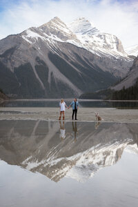 couple shown at kinney lake in Mt.Robson provincial park walking their dog