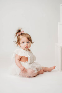 Charleston Cake Smash Photographer- Baby looks into the camera during Milestone Portraits at Holy City Babies Portrait Studio in Charleston, SC.