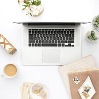 Flatlay of Mac laptop on a white desk