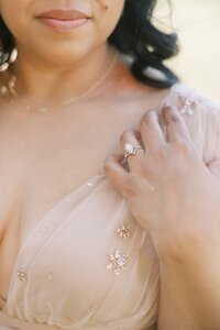 Close-up detail of the mother of the Dilorio family wearing a blush dress and diamond ring in Las Vegas, highlighting elegant styling during a portrait session.