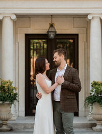 traditional boston engagement session. women holds hand over mans heart and they look at each other lovingly.