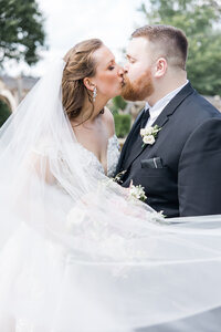 The bride and groom kissing in front of the green truck at Rivercrest Farm photographed by akron ohio wedding photographer