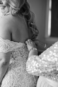 Mom buttoning up bride in Springfield, LA.