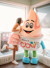 Senior portrait in Gulf Shores, Alabama — playfully pretending to kiss the mascot statue inside
TCBY.