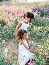 Two little girls collecting flowers in Discovery Park