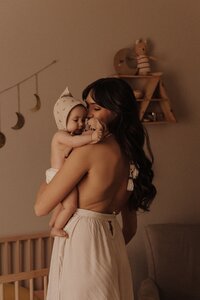 In-Home lifestyle Portrait of a mother holding newborn