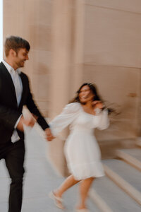 bride and groom running on the sidewalk