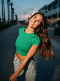 Senior portrait at The Wharf in Orange Beach, Alabama — wide-angle waist-up hair flip with the
Ferris wheel and palm trees in the background.