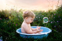 Charleston Baby Milestone Photographer - Baby plays in a splash bath during his Milestone Portrait Session at Holy City Babies Portrait Studio in Charleston, SC.