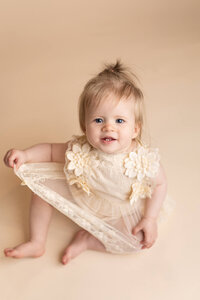 6 month baby girl smiles during her milestone session at Jennifer Brandes Photography in New Ulm, Minnesota.