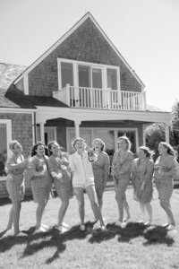 Bride pops a bottle of champagne surrounded by bridesmaids.