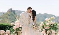 Bride Megan with soft, flowing waves, a Kohnur romantic wedding hairstyle and radiant timeless wedding makeup, embracing groom Eliezer in golden hour light at Cielo Farms.