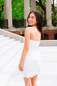 Vanderbilt senior wearing white and smiling over her shoulder smiling at the camera