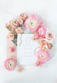 wedding invitation surrounded by flowers