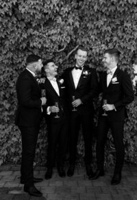 Black and white portrait of groom with groomsmen outdoors