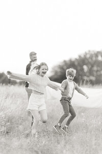 Black and white photo of 2 children running in an open field at a Fort Worth TX park.
