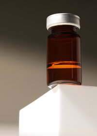 Single amber jar on a white plinth, studio product still