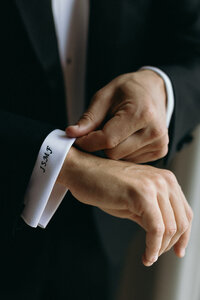 Groom fastening his suit during wedding preparations in San Sebastián