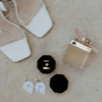 Some of the most elegant bridal details from the couples beach wedding in Cancun, Mexico. The bride incorporated her white shoes, perfume, wedding rings, and earrings for the photos.