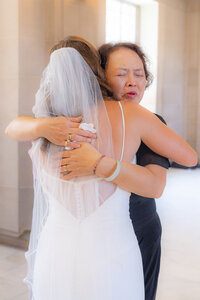 bride hugs mother of groom at san francisco city hall wedding