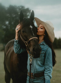 Senior portrait at Triple T Farms in Fruitdale, Alabama — close-up with her horse, kissing his
forehead.