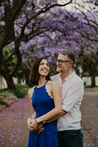 A couple photographed in front of an avenue of Jacarandas in Rosebank, Johannesburg.