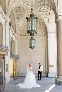 bride and groom posed looking out into distance in detroit
