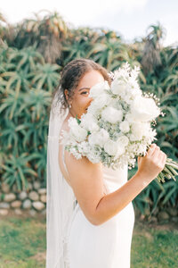 Bride holds white floral wedding bouquet