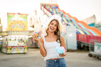 Senior portrait at the Greater Gulf State Fair in Mobile, Alabama — eating cotton candy in front
of a lemonade stand.