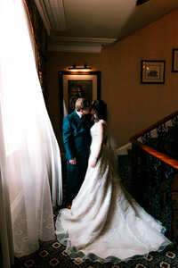newlyweds kissing by stairs together at Exeter rougemont captured by a colourful candid wedding photographer