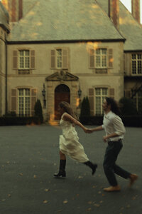Couple running in front of a mansion in Newport, RI