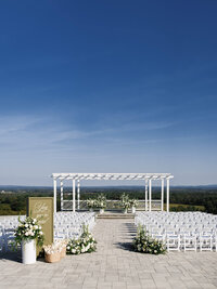 A wide, high-angle view of an outdoor wedding ceremony at The View at Bluemont, showcasing refined composition and the intentional imagery of the vast mountain horizon.