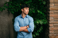 A boy from Pewaukee High School stands in Downtown Waukesha wearing a blue button down.