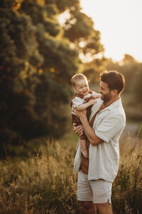 Matt holding his son during a family photoshoot in new plymouth