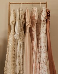 a clothing rack with flowy dresses hanging on it