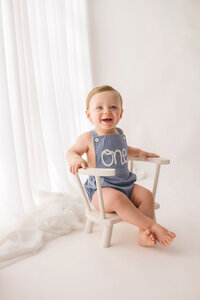 Baby smiles at the camera during Baby Milestone Portrait Session at Holy City Babies Portrait Studio in Charleston, SC.