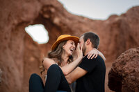 Playful couple laughing together in front of red rock formations at Papago Park