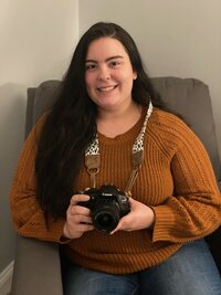 Portrait of a photographer with a camera and long brown hair