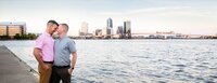 Jacksonville, FL portrait session capturing Engagement capturing a quiet moment between an engaged couple along the riverfront, the city skyline and historic Landing rising in the background.