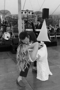 Groom kisses Bride while they dip on the dance floor during their first dance.