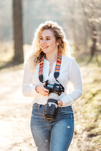 Zakelijk portret van fotografe met camera en telelens