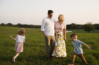 children run in circles around their parents at their farm in marquez, texas.