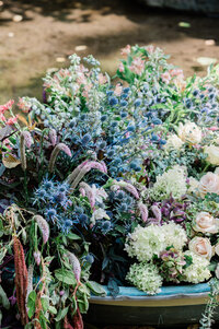Blue pops of flowers in a white wedding arrangement