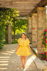 A young lady from Pewaukee High School walk through a trellis in Waukesha's Frame Park for her senior portraits.