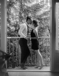 couple kissing while standing on their apartment balcony in Amsterdam