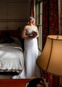 Bride looking out the window before her wedding at mcmenamins edgefield in Troutdale, Oregon.