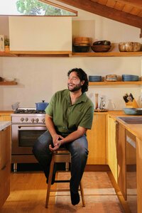 Man seated on a kitchen stool in warm afternoon light