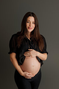 expecting mom with hands cradling bump during intimate maternity portrait session