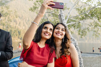 Bride and the maid of honor smile as they take a selfie